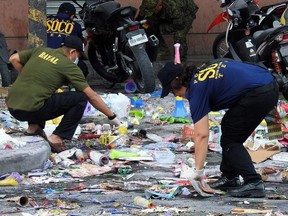 Police officers investigate at the site of an explosion outside a shopping mall in Cotabato City on the southern island of Mindanao on December 31, 2018. - Two people were killed and at least 32 others wounded on December 31 after a bomb went off outside a shopping mall in the southern Philippine city of Cotabato, police said.