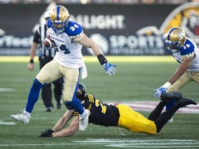 Winnipeg Blue Bombers linebacker Jesse Briggs (34) eludes a tackle by Hamilton Tiger-Cats linebacker Nick Shortill (23) during a faked punt to get a first down during first quarter CFL game action in Hamilton, Ont., on June 29, 2018. The Winnipeg Blue Bombers have signed the Canadian linebacker to a two-year contract.