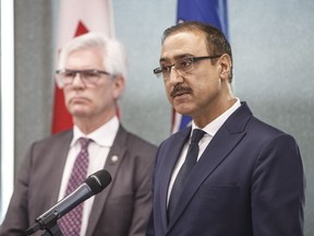 Canada's Minister of Natural Resources Amarjeet Sohi, left, and Canada's Minister of International Trade Diversification Jim Carr speak during a press conference to announce support for Canada's oil and gas sector, in Edmonton on Tuesday, Dec. 18, 2018.