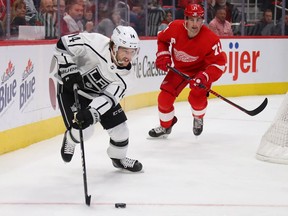 Brendan Leipsic (14) of the Los Angeles Kings controls the puck in front of Dylan Larkin #71 of the Detroit Red Wings during the first period at Little Caesars Arena on December 10, 2018 in Detroit, Michigan.