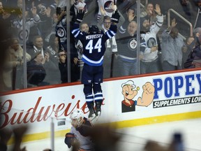 Winnipeg Jets defenceman Josh Morrissey jumps into the end boards to celebrate his overtime goal against the Edmonton Oilers in Winnipeg last night. (Kevin King/Winnipeg Sun)