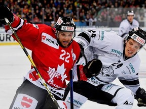 Team Canada's Zach Boychuk, left, and Ice Tigers's Marcus Weber, right, challenge for the puck during a Spengler Cup 2018 ice hockey match between Team Canada and Thomas Sabo Ice Tigers in Davos, Switzerland, Sunday, Dec. 30, 2018.