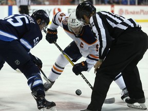 Winnipeg Jets centre Mark Scheifele (left) and Edmonton Oilers centre Connor McDavid face off in Winnipeg on Tues., Oct. 16, 2018. Kevin King/Winnipeg Sun/Postmedia Network