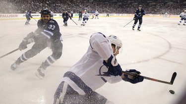 Tampa Bay Lightning forward Adam Erne (right) loses his balance turning away from Winnipeg Jets defenceman Dustin Byfuglien in Winnipeg on Sun., Dec. 16, 2018. Kevin King/Winnipeg Sun/Postmedia Network