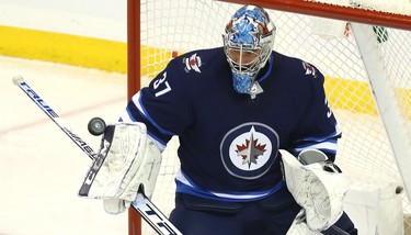 Winnipeg Jets goaltender Connor Hellebuyck steers aside a Tampa Bay Lightning shot in Winnipeg on Sun., Dec. 16, 2018. Kevin King/Winnipeg Sun/Postmedia Network