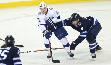 Tampa Bay Lightning forward Brayden Point (centre) wraps a pass around Winnipeg Jets defenceman Jacob Trouba in Winnipeg on Sun., Dec. 16, 2018. Kevin King/Winnipeg Sun/Postmedia Network