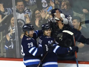 Winnipeg Jets centre Mark Scheifele (right) celebrates his overtime goal against the Tampa Bay Lightning in Winnipeg with Patrik Laine on Sunday.