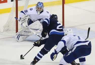 Tampa Bay Lightning goaltender Andrei Vasilevskiy goes for the poke-check as Winnipeg Jets forward Patrik Laine moves in ahead of defenceman Victor Hedman in Winnipeg on Sun., Dec. 16, 2018. Kevin King/Winnipeg Sun/Postmedia Network