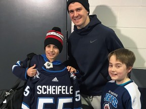 Arsenii Varchuk (left) and friend Jayden Schritt meet Winnipeg Jets centre Mark Scheifele at Bell MTS Centre in Winnipeg on Thursday, Dec. 13.