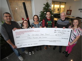 From the left; Ravinder Lidder, Tracy Drew Joy Stadnichuk, Steven Guercio, Kai Madsen, and Tamara Kruk pose with a giant cheque for the Christmas Cheer Board.