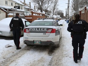 Police maintain a barrier in the backlane of the 400 block between Victor and Toronto Streets, looking south from Ellice Avenue, on Tuesday, Dec. 25, 2018.