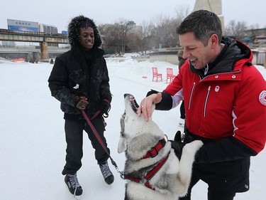 Kane, a 27-week-old Siberian Husky owned by Ronaldo Boney (left) gets frisky with Mayor Brian Bowman after a ceremony to mark the official opening of the Red River Mutual skating trail at The Forks in Winnipeg on Tues., Jan. 23, 2018. Kevin King/Winnipeg Sun/Postmedia Network