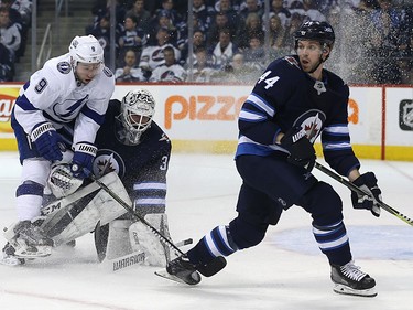 Winnipeg Jets defenceman Josh Morrissey (right) looks for a place to pass as Tampa Bay Lightning centre Tyler Johnson bumps goaltender Michael Hutchinson in Winnipeg on Tues., Jan. 30, 2018. Kevin King/Winnipeg Sun/Postmedia Network