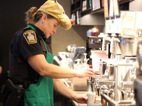 Const. Andrea Lefort pours a drink as an honorary Starbucks barista in support of Siloam Mission. 
Luke Rempel/Winnipeg Sun/Postmedia Network