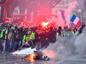 Protesters wearing yellow vests (gilets jaunes) set up a barricade during a demonstration against rising costs of living they blame on high taxes in Bordeaux, south-western France, on Dec. 15, 2018.