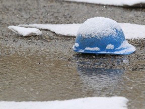 A Construction workers hard hat sits in a wet parking lot at Brentwood Mall in northwest Calgary, Alta on Sunday March 30, 2014. Jim Wells/Calgary Sun/QMI Agency