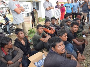 Suspected Rohingya people sit on the ground as they arrive in Idi Rayeuk, East Aceh, Indonesia, on Dec. 4, 2018.