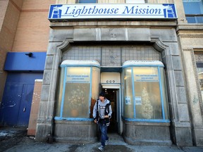 A man carries his pizza lunch out of the Lighthouse Mission soup kitchen on Main Street in Winnipeg on Sun., Dec. 9, 2018. Kevin King/Winnipeg Sun/Postmedia Network