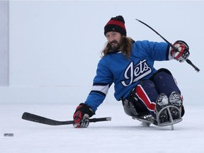 Brandon Kudlak goes for the puck during a sledge hockey game at Dakota Community Centre in Winnipeg Tuesday.