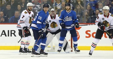 Winnipeg Jets centre Mark Scheifele (second from left) and Kyle Connor (second from right) set up in front of Chicago Blackhawks goaltender Cam Ward on the power-play, with Brent Seabrook (left) and Brandon Manning (right) defending in Winnipeg on Tues., Dec. 11, 2018. Kevin King/Winnipeg Sun/Postmedia Network