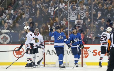 Winnipeg Jets centre Mark Scheifele (centre) celebrates his power-play goal against the Chicago Blackhawks in Winnipeg on Tues., Dec. 11, 2018 with Kyle Connor. Brent Seabrook, goaltender Cam Ward and Brandon Manning (from left) reacts for the Blackhawks. Kevin King/Winnipeg Sun/Postmedia Network