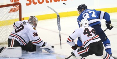 Chicago Blackhawks goaltender Cam Ward loses his stick with Winnipeg Jets forward Nikolaj Ehlers driving the net and Jan Rutta defending in Winnipeg on Tues., Dec. 11, 2018. Kevin King/Winnipeg Sun/Postmedia Network