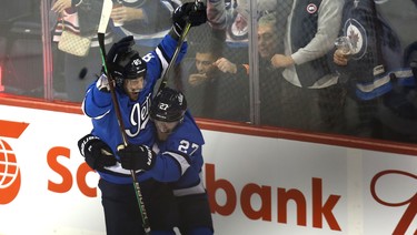 Winnipeg Jets forward Mathieu Perreault (left) celebrates his third-period, power-play goal against the Chicago Blackhawks with Nikolaj Ehlers in Winnipeg on Tues., Dec. 11, 2018. Kevin King/Winnipeg Sun/Postmedia Network