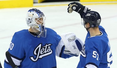 Winnipeg Jets goaltender Laurent Brossoit (left) is congratulated by defenceman Tyler Myers after a win over the Chicago Blackhawks in Winnipeg on Tues., Dec. 11, 2018. Kevin King/Winnipeg Sun/Postmedia Network