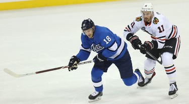 Winnipeg Jets centre Bryan Little (left) hustles after a loose puck with Chicago Blackhawks forward Brendan Perlini in Winnipeg on Tues., Dec. 11, 2018. Kevin King/Winnipeg Sun/Postmedia Network