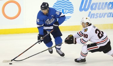 Winnipeg Jets forward Blake Wheeler (left) turns inside on Chicago Blackhawks forward Brandon Saad in Winnipeg on Tues., Dec. 11, 2018. Kevin King/Winnipeg Sun/Postmedia Network