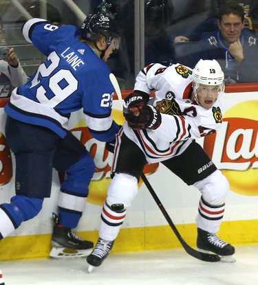 Chicago Blackhawks centre Jonathan Toews spins and fires the puck out of his zone with Winnipeg Jets Patrik Laine checking him in Winnipeg on Tues., Dec. 11, 2018. Kevin King/Winnipeg Sun/Postmedia Network