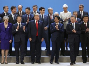 World leaders gather for a group photo at the start of the Group of 20 summit at the Costa Salguero Center in Buenos Aires, Argentina, Friday, Nov. 30, 2018. Bottom row from left are Britain's Prime Minister Theresa May, France's President Emmanuel Macron, President Donald Trump, Japan's Prime Minister Shinzo Abe, Argentina's U.S. President Mauricio Macri and China's President Xi Jinping. Behind are European Council's President Donald Tusk, the Netherlands' Prime Minister Mark Rutte, unidentified, Spain's Prime Minister Pedro Sanchez, unidentified, Prime Minister Justin Trudeau, unidentified, International Monetary Fund Managing Director Christine Lagarde, South Korea's President Moon Jae-in, unidentified, and Chile's President Sebastian Pinera.