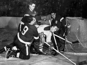 DETROIT, MI - APRIL 10: Red Kelly #4 and teammate Gordie Howe #9 of the Detroit Red Wings sandwich Maurice Richard #9 of the Montreal Canadiens before he can score on goalie Terry Sawchuk #1 during an NHL game at the Detroit Olympia Stadium on April 10, 1952 in Detroit, Michigan. (Photo by Bruce Bennett Studios/Getty Images) ORG XMIT: GETTY HOCKEY ARCHIVES ORG XMIT: POS1607282015472950