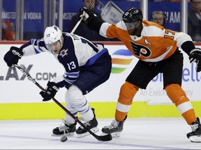 Winnipeg Jets' Brandon Tanev, left, and Philadelphia Flyers' Wayne Simmonds chase after the puck during the first period of an NHL hockey game, Monday, Jan. 28, 2019, in Philadelphia. (AP Photo/Matt Slocum)