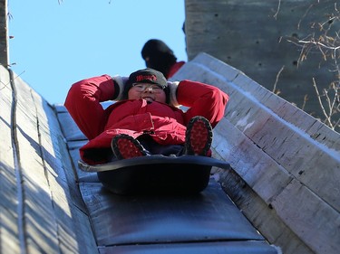 A boy holds his tuque as he rides the giant toboggan slide during Winterfest at Fort Whyte Alive in Winnipeg on Sun., Jan. 20, 2019. Kevin King/Winnipeg Sun/Postmedia Network