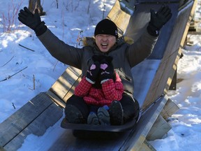 A man celebrates while his daughter cannot bear to look while riding the toboggan slide during Winterfest at FortWhyte Alive in Winnipeg on Sunday.