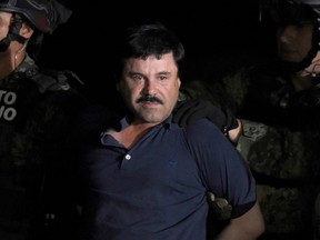 Drug kingpin Joaquin "El Chapo" Guzman is escorted into a helicopter at Mexico City's airport, following his recapture during an intense military operation in Los Mochis, in Sinaloa State, on Jan. 8, 2016.