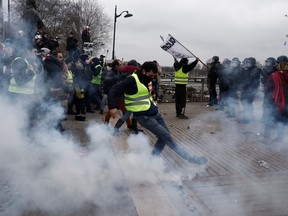 Demonstrators throw back tear gas canisters to riot police officers on Jan. 5, 2019 in Paris, during an anti-government demonstration called by the yellow vest "Gilets Jaunes" movement. (SAMEER AL-DOUMY/AFP/Getty Images)