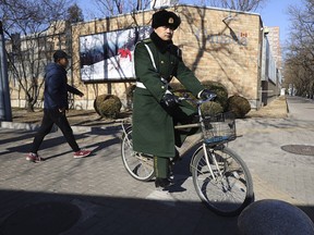 A Chinese paramilitary policeman rides past the Canadian embassy in Beijing, China, Wednesday, Jan. 16, 2019. (AP Photo/Ng Han Guan)