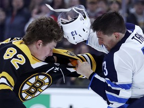 Bruins centre Trent Frederic (right) fights with Jets forward Brandon Tanev last night in Boston.  The Associated press