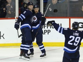 Winnipeg Jets centre Bryan Little (centre) celebrates his overtime goal against the Anaheim Ducks in Winnipeg with Jacob Trouba (left) and Patrik Laine yesterday. Kevin King/Winnipeg Sun