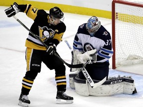 Winnipeg Jets goaltender Connor Hellebuyck makes a save on Penguins centre Evgeni Malkin on Friday. AP PHOTO