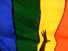 In this file photo taken on July 13, 2014 members and supporters of the lesbian, gay, bisexual, transgender (LGBT) community walk with a rainbow flag during a rally. (Getty Images)