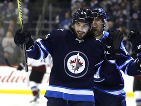 Jets forward Mathieu Perreault (left) celebrates his first-period goal against the  Avalanche on Jan. 9, 2019. Kevin King/Winnipeg Sun/Postmedia Network
