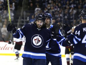 Jets forward Mathieu Perreault (left) celebrates his first-period goal against the  Avalanche on Tuesday. Kevin King/Winnipeg Sun/Postmedia Network