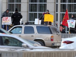 Police watched from nearby buildings and waited in vehicles while a small group of individuals staged a demonstration at Portage Ave and Main Street, in Winnipeg.  Thursday, January 10/2019 Winnipeg Sun/Chris Procaylo/stf
