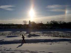 Sundogs appear on either side of the sun courtesy of an arctic air mass that is bringing extreme cold temperatures to Winnipeg.  The jogger is running along Waterfront Dr.  Thursday January 17, 2019. Chris Procaylo/Winnipeg Sun