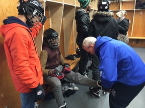 Camp Manitou Director Rick Bochinski tightens the skates of one of the Congo Canada Charity Foundation participants in the True North Youth Foundation (TNYF) last of six 2018-19 "Welcome to Winnipeg" events at Camp Manitou near Headingley on Saturday.
