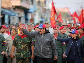 In this government handout released by the Venezuelan presidency, Nicolas Maduro (C), his wife Cilia Flores (R), attend a military ceremony. Many believe Maduro's day are numbered.