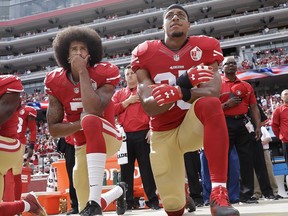 In this Oct. 2, 2016 file photo, San Francisco quarterback Colin Kaepernick, left, and safety Eric Reid kneel during the national anthem in Santa Clara, Calif. (AP Photo/Marcio Jose Sanchez, File)
